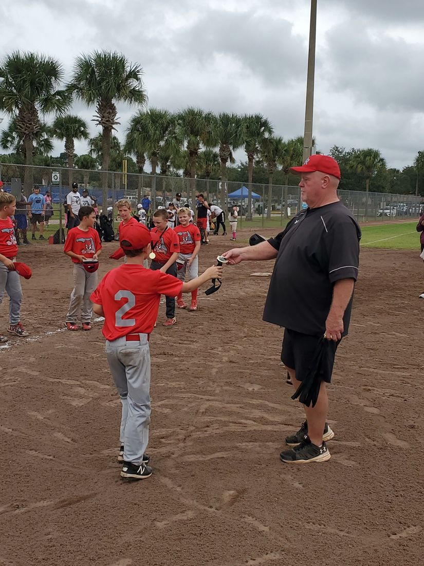 Coach Rick handing out medals to a young team