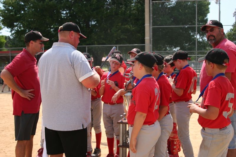 Coach Rick and his team gathered around a championship trophy
