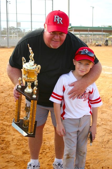 Coach Rick with a young player and a tournament trophy